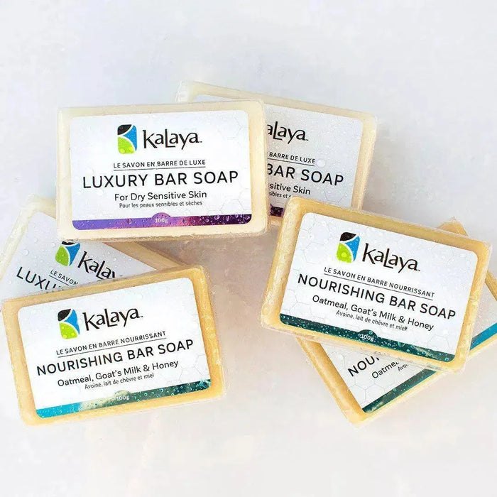 Piled collection of bars of soap, including Kalaya Luxury Bar Soap and Kalaya Nourishing Bar Soap