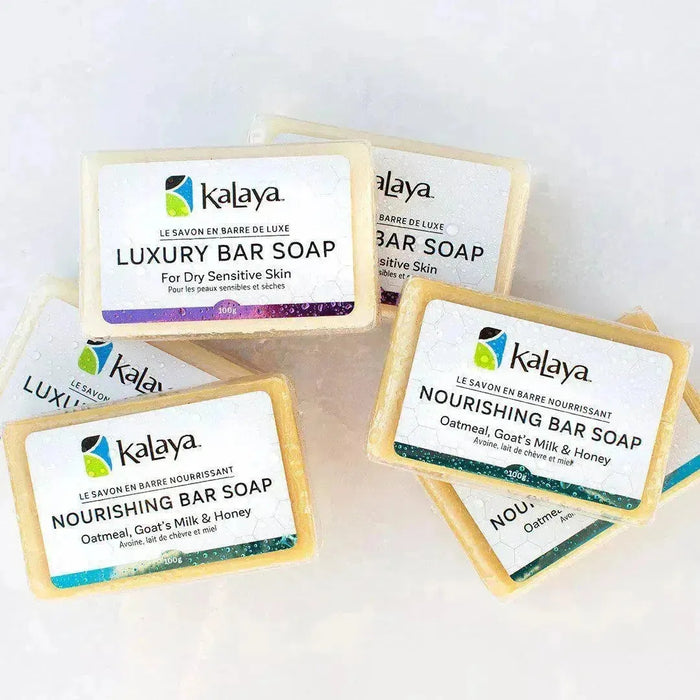 Piled collection of bars of soap, including Kalaya Luxury Bar Soap and Kalaya Nourishing Bar Soap